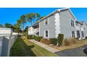 Side view of building showing gray exterior and landscaping at 7713 Hillside Ct # 201, Hudson, FL 34667