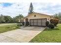 Front view of a house with a large driveway and manicured lawn at 102 Stafford Dr, Palm Harbor, FL 34684