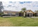 Ranch style home with a spacious lawn and two-car garage at 102 Stafford Dr, Palm Harbor, FL 34684