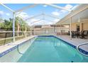Relaxing screened-in pool with patio furniture at 1066 Larkin Rd, Spring Hill, FL 34608