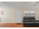 Living room with dark gray reclining furniture and hardwood floors at 1320 Moreland Dr # 20, Clearwater, FL 33764