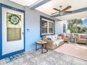 Relaxing front porch with wicker furniture and ceiling fan at 1447 Santa Anna Dr, Dunedin, FL 34698