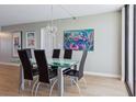 Bright dining room with glass table and black chairs at 17940 Gulf Blvd # 15C, Redington Shores, FL 33708