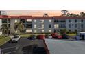 Exterior view of condo building with parking lot in front at 2700 Bayshore Blvd # 1305, Dunedin, FL 34698