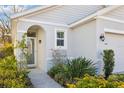 Inviting front entry with a walkway and lush landscaping at 32857 Brooks Hawk Ln, Wesley Chapel, FL 33543