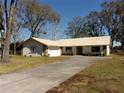 Tan metal roof ranch home with large yard and driveway at 3736 Florida Ranch Blvd, Zephyrhills, FL 33541