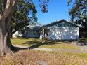 Single story home with two car garage and landscaped lawn at 7711 Innis Ct, St Petersburg, FL 33709