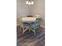 Small dining area with white table and four chairs at 209 Ne Lincoln N Cir # 109, St Petersburg, FL 33702