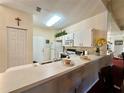 Bright kitchen features white cabinetry and breakfast bar at 2116 Nantucket Dr # 19, Sun City Center, FL 33573