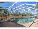 Inviting screened pool and spa with brick pavers and canal view at 3998 South Cir, Largo, FL 33774