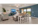 Open living room with a comfortable couch, large TV, and access to a balcony at 10043 Crooked Creek Dr # 202, Venice, FL 34293