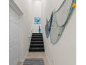 Interior view of a staircase with dark carpeting and coastal wall decor at 10043 Crooked Creek Dr # 202, Venice, FL 34293