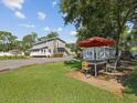 Outdoor patio area with a table, chairs, and a large umbrella at 1055 Philippe Pkwy, Safety Harbor, FL 34695