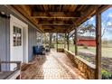 Brick porch with wooden beams, stone accents, and comfortable seating at 12519 Fairwinds Rd, Hudson, FL 34669