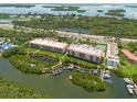 Aerial view showcasing waterfront property with boat docks and lush landscaping at 1695 Pinellas Bayway S # E4, Tierra Verde, FL 33715