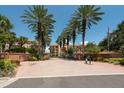 Gated entrance to Hidden Lagoon community with palm trees and brick driveway at 1695 Pinellas Bayway S # E4, Tierra Verde, FL 33715