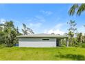 Gray house with covered patio and grassy backyard at 191 Prineville St, Port Charlotte, FL 33954