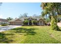 Beautiful home with a large front yard, mature trees, and a three-car garage at 512 Creekside Ct, Safety Harbor, FL 34695