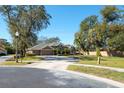 House with a basketball court, large yard, and mature trees at 512 Creekside Ct, Safety Harbor, FL 34695