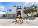 Two story home with white exterior, metal roof, and landscaped yard at 519 Loquat Dr, Anna Maria, FL 34216