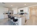 Modern kitchen with stainless steel appliances and granite island at 5462 Logan Cave Ave, Wimauma, FL 33598