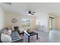 Living room with gray sectional sofa, coffee table, and large window at 5462 Logan Cave Ave, Wimauma, FL 33598