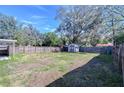 Large backyard with a wooden fence, storage shed, and ample space at 5836 8Th St, Zephyrhills, FL 33542