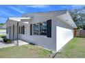 White house exterior with black shutters and small porch at 5836 8Th St, Zephyrhills, FL 33542