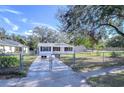 Newly renovated home with a spacious front yard and a chain link fence at 5836 8Th St, Zephyrhills, FL 33542