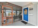 Screened porch with blue door and a bench at 1866 Michigan Ne Ave, St Petersburg, FL 33703