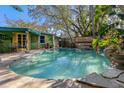 Relaxing kidney-shaped pool with surrounding landscaping at 212 20Th Ave, Indian Rocks Beach, FL 33785