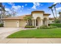 Elegant home with a welcoming porch and attractive landscaping at 2867 Grey Oaks Blvd, Tarpon Springs, FL 34688