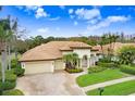 Luxury home with tile roof and lush landscaping, two-car garage at 2867 Grey Oaks Blvd, Tarpon Springs, FL 34688