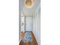 Bright entryway with wood flooring, a runner, and built-in storage at 4725 Cove Cir # 211, St Petersburg, FL 33708