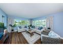 Spacious living room featuring light walls, wood flooring, and ample natural light at 4725 Cove Cir # 211, St Petersburg, FL 33708