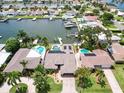 Aerial view showcasing a waterfront property with a private dock and pool at 725 Capri Blvd, Treasure Island, FL 33706