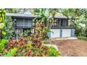 House with a screened porch and two-car garage, surrounded by trees at 751 Pinellas Point S Dr, St Petersburg, FL 33705