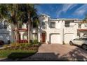 White townhouse with red tile roof, two-car garage, and landscaping at 10308 Saville Rowe Ln, Tampa, FL 33626