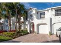 White townhouse with red tile roof, two-car garage, and landscaping at 10308 Saville Rowe Ln, Tampa, FL 33626