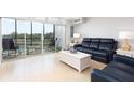 Living room with water views and access to balcony at 10355 Paradise Blvd # 207, Treasure Island, FL 33706