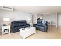 Bright living room with light colored floors and couches at 10355 Paradise Blvd # 207, Treasure Island, FL 33706