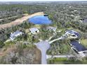 Aerial view of a cul-de-sac neighborhood with several houses and a pond at 13653 Heritage Way, Sarasota, FL 34240