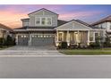 Two-story home with gray siding, three-car garage, and landscaping at 14215 Swiss Bridge Dr, Riverview, FL 33579