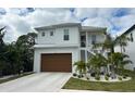 Two-story house with white exterior, brown garage door, and landscaping at 1840 Douglas Ave, Dunedin, FL 34698