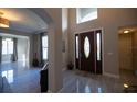 Bright and spacious entryway with elegant flooring and a view into the living room at 26932 Sea Breeze Way, Wesley Chapel, FL 33544
