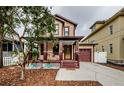 Tan house with maroon accents, a garage, and a well-maintained lawn at 308 E Ross Ave, Tampa, FL 33602