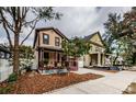 Two story home on a tree-lined street with a landscaped front yard at 308 E Ross Ave, Tampa, FL 33602