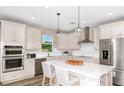 Well-equipped kitchen with stainless steel appliances, quartz countertops, and a center island with barstool seating at 4296 Big Sky Dr, Spring Hill, FL 34604