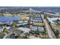 Aerial view of community with tennis courts, pool, golf course, and lake at 4946 Mill Pond Rd # 3180, Wesley Chapel, FL 33543