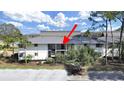 Two-story building exterior with a metal roof, landscaping, and parking at 4946 Mill Pond Rd # 3180, Wesley Chapel, FL 33543